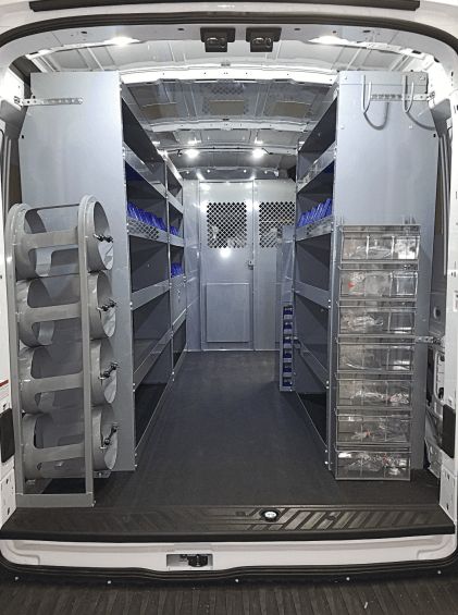 Aménagement intérieur d'un fourgon utilitaire avec étagères métalliques.