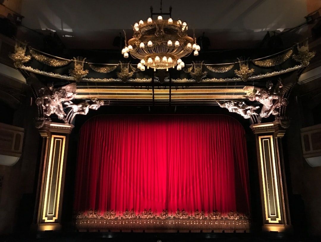 Scène de théâtre ornée, encadrée par un rideau rouge fermé
