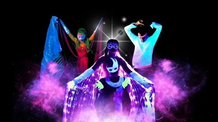 Quatre artistes masqués dans une mise en scène fluorescente et colorée